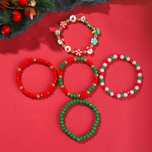 Flat lay of colorful Christmas themed beaded bracelets with Santa and tree charms