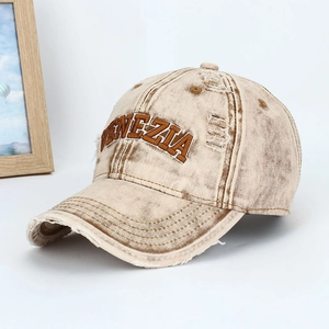 Close-up of distressed cotton baseball cap with Venezia embroidery and ripped details