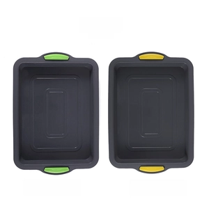 Silicone brownie pans in dark grey with green and yellow non-slip handles detail view
