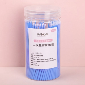 Close-up of 100pcs blue micro lash brushes for eyelash extensions in a clear round jar