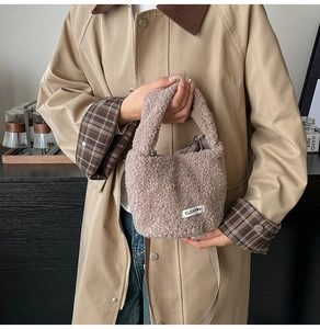 Détail du sac seau en laine d'agneau pelucheuse rose poudré avec étiquette et bandoulière