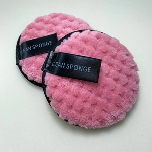 Close-up of pink round makeup pads with waffle texture and Clean Sponge woven label