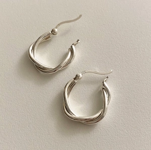 Detail shot of S925 sterling silver twisted hoop earrings with hallmark engraving