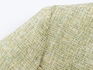 Close-up detail of green and yellow tweed woven fabric texture with fine fiber patterns