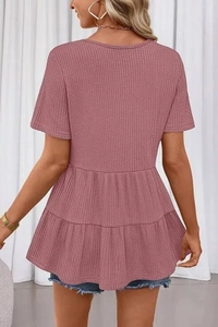 Vue détaillée du haut rose en maille gaufrette avec ourlet à basque et texture de tissu