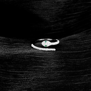 Silver snake wrap ring featuring micro-pave white zircon and striking green gemstone eyes