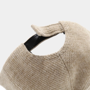 Detail of oatmeal knitted baseball cap showing thick texture and velcro strap adjustment