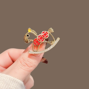 Elegant gold rocking horse brooch with red oil drips and sparkling diamond accents