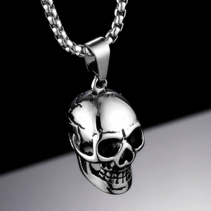 Close-up of a silver oversized skull pendant necklace with a detailed box chain design