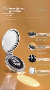 Detail of silver folding hairbrush with 15mm bristles and integrated mirror
