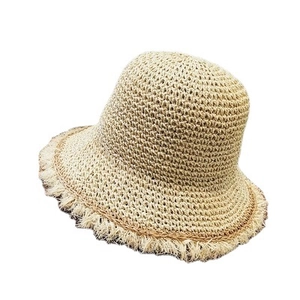 Women's foldable straw sun hat with frayed brim and natural weave texture in light beige