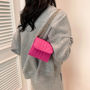 Magenta leather crossbody chain bag shown on model for size and style reference