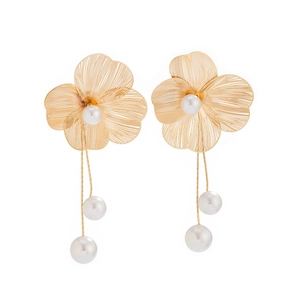 Detailed macro view of gold wire hollow gingko flowers and dangling pearl tassels earrings