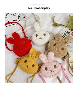 Multiple colors of plush rabbit crossbody bags for kids shown in a flat lay display