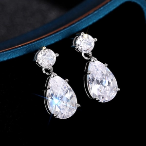 Gros plan de boucles d'oreilles en argent avec cristaux brillants sur fond de velours