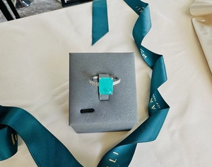 Detail of 8x10mm emerald cut teal gemstone ring set in sterling silver on display stand