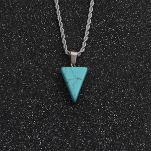 Vue macro d'un pendentif triangle en turquoise avec veines noires sur chaîne argentée