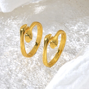 Macro view of golden adjustable hugging hands rings on a water-textured glass background