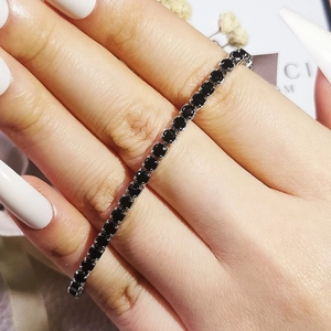 Macro view of classic tennis bracelet with black zircon stones in a four-prong setting