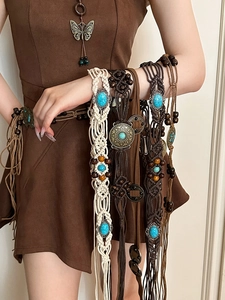Close-up of woven waist chains with turquoise beads and long decorative tassels