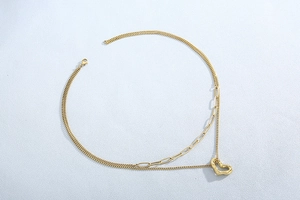 Detail view of gold layered snake chain necklace with liquid metal heart pendant