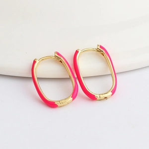 Detailed view of U-shaped oval hoop earrings featuring pink enamel and gold plating