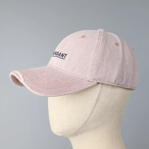 Close-up of pink cotton baseball cap featuring black ENDANT embroidery and distressed brim