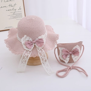 Detail of pink straw sun hat and matching crossbody bag with lace ribbon and floral bows