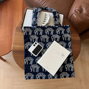 Navy canvas tote bag with white sheep embroidery and wide shoulder straps for daily commute