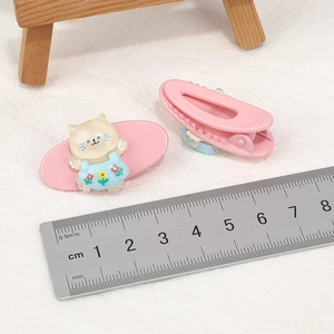Pink cartoon cat hair clip and simple barrette set shown with a ruler for size