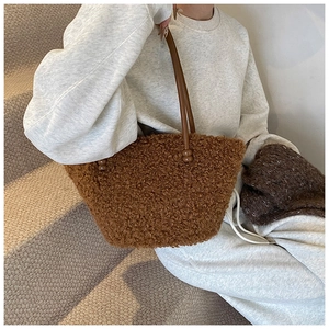 Gros plan d'un sac cabas marron en peluche avec anses en cuir sur des marches