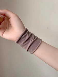 Close-up of a soft elastic brown fabric wristband worn on a wrist for daily protection