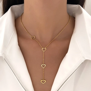 Close-up of a gold titanium Y-shaped necklace with four hollow heart pendants on a woman