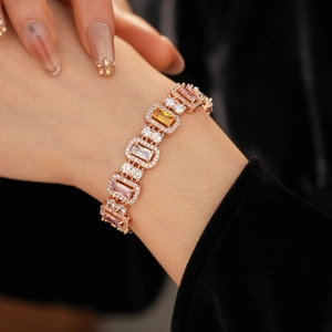 Close-up of rose gold bracelet featuring colorful square-cut gemstones and halo crystals