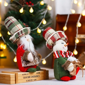 Standing Christmas Santa and Snowman plush figurines in plaid hats on wooden crate