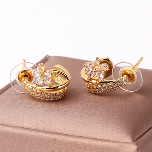 Detail of gold flower hoop earrings with clear zircon stones on a jewelry box
