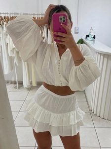 White cotton two-piece set with puff sleeve buttoned crop top and tiered ruffle mini skirt
