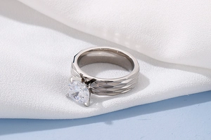 Macro detail of silver titanium ring with geometric scale texture and round cut gemstone