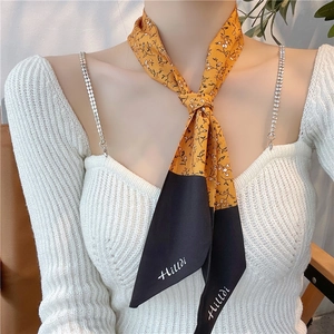 Nastro per capelli in seta con motivo floreale giallo e nero indossato da una modella