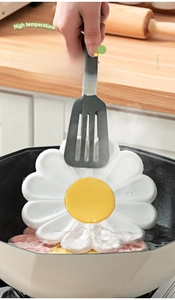 Detail showing daisy silicone heat resistant mat being lifted from boiling water