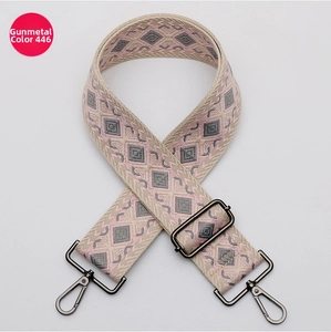 Detalle de correa tejida jacquard en rosa y gris con ganchos giratorios metálicos