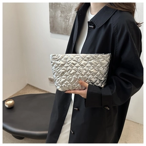 Close-up of silver quilted handbag with heart pattern and metallic texture