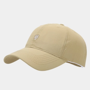 Detail of khaki quick-dry baseball cap featuring a white H shield embroidery on the front