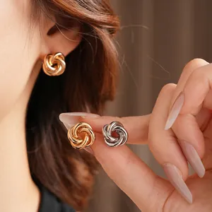Elegant twisted metal knot stud earrings in polished gold and silver finishes