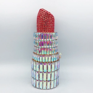 Detailed view of lipstick-shaped clutch featuring red rhinestones and crystal body