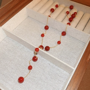 Retro Y-shape necklace with vibrant red agate beads and gold-plated chain in jewelry box