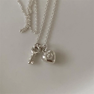 Minimalist 925 sterling silver heart key necklace for women shown on a white background