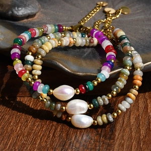 Détail macro de bracelets bohèmes avec perles d'eau douce sur un plat en céramique