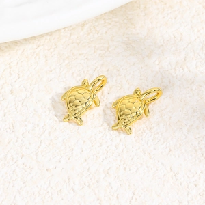 Macro shot of two golden turtle pendants with shell texture for DIY jewelry making