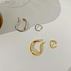 Detailed view of geometric gold and silver non-pierced ear cuffs in U-shaped design